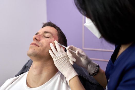 Patient closing eyes while getting a rejuvenation treatment with botox injection