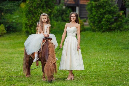 mother with daughter and pony