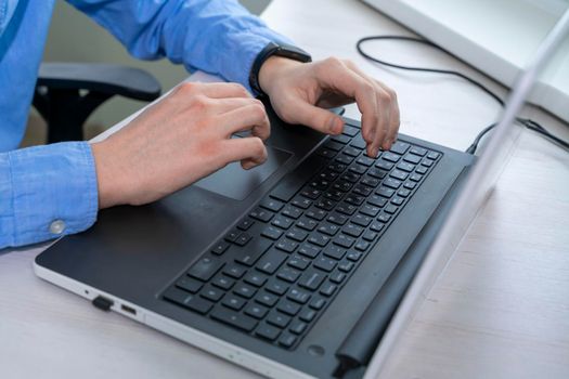Close up of mans hand typing on laptop keyboard