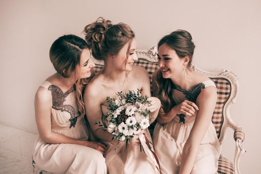 cheerful bride with her girlfriends sitting together