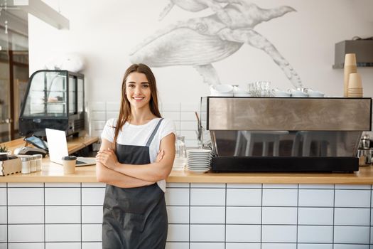 Coffee Business owner Concept - Portrait of happy attractive young beautiful caucasian barista in apron smiling at camera in coffee shop counter.