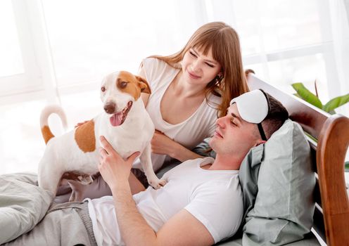 Couple in the bed with dog