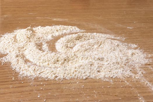 A pile of sifted flour on a  table. Sprinkled flour on a table