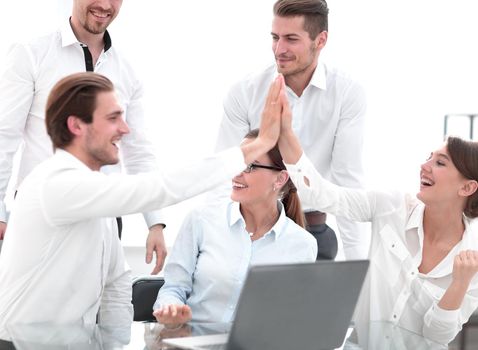 employees giving a high five at an office meeting.
