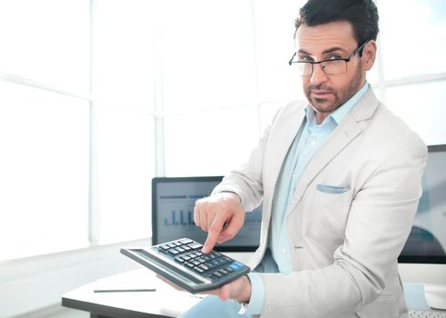 confident businessman pointing to calculator