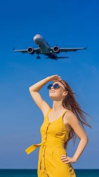 Woman have fun on the beach watching the landing planes. Traveling on an airplane concept. Text space. Island Phuket in Thailand. Impressive paradise. Hot beach Mai Khao. Amazing landscape VERTICAL FORMAT for Instagram mobile story or stories size. Mobile wallpaper