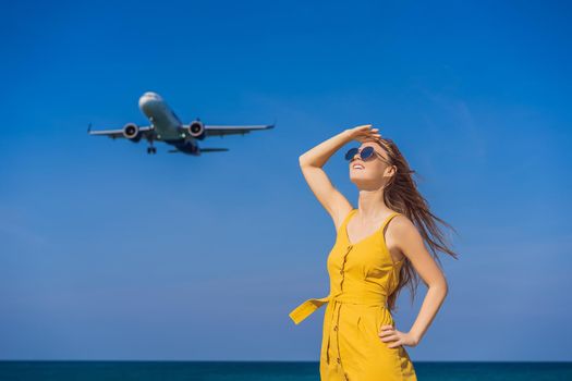 Woman have fun on the beach watching the landing planes. Traveling on an airplane concept. Text space. Island Phuket in Thailand. Impressive paradise. Hot beach Mai Khao. Amazing landscape