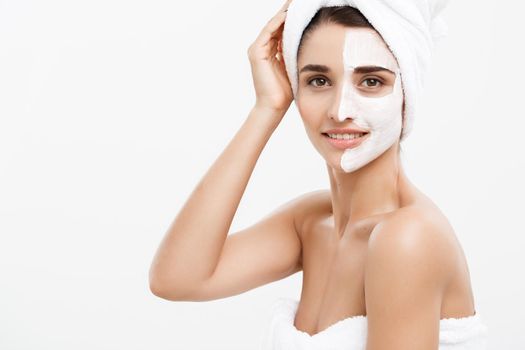 Beauty Skin Care Concept - Beautiful Caucasian Woman Face Portrait applying cream mask on her facial skin white background.