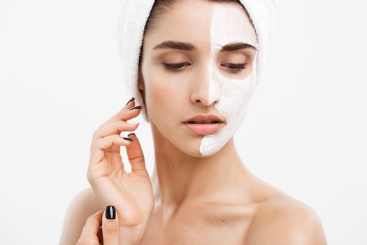Beauty Skin Care Concept - Beautiful Caucasian Woman Face Portrait applying cream mask on her facial skin white background.