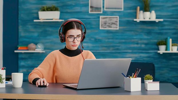 University student using headphones and laptop to attend online class