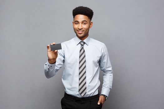 Business Concept - Happy handsome professional african american businessman showing name card to client.