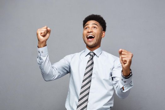 Business Concept - Confident happy young African American throwing fists in air celebrating for success projects.