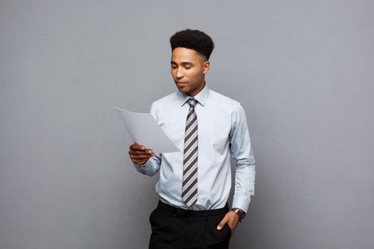 Business Concept - handsome young professional african american businessman concentrated reading on document paper.