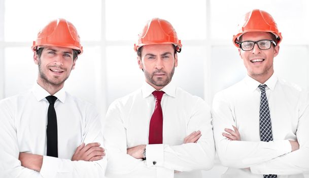 close up.three confident business men in protective helmets