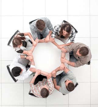 top view.The business team hold hands, forming a circle