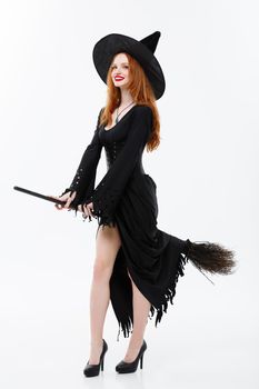 Halloween Witch Concept - Full-length Happy elegant witch with broomstick for celebrating halloween party over white background.