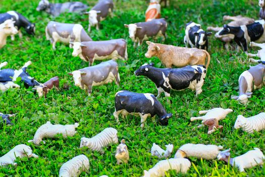 Toy animals to pasture on a green meadow