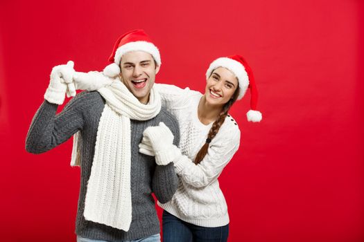 Christmas concept - Happy young couple in sweatesr celebrating christmas with playing and dancing