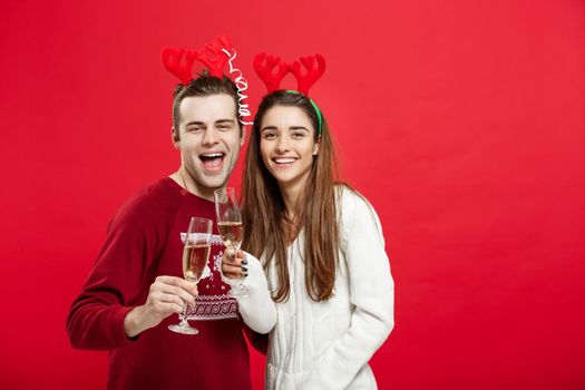 Christmas concept - Happy young couple in sweaters celebrating christmas with Champagne