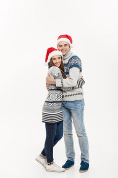 Christmas concept - Full-length Young attractive caucasian couple giving a hug celebrating for Christmas day.
