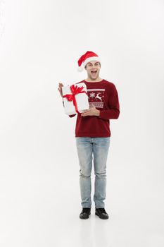 Christmas Concept - Full-length handsome young man in sweater wi