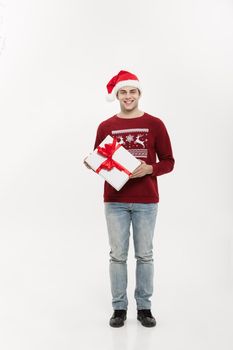 Christmas Concept - Full-length handsome young man in sweater wi