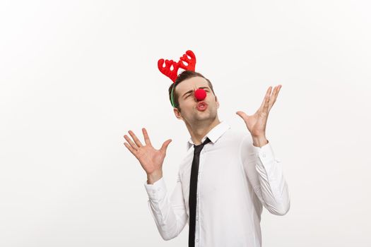 Christmas Concept - Handsome Business man wearing reindeer hairband making funny facial expression.