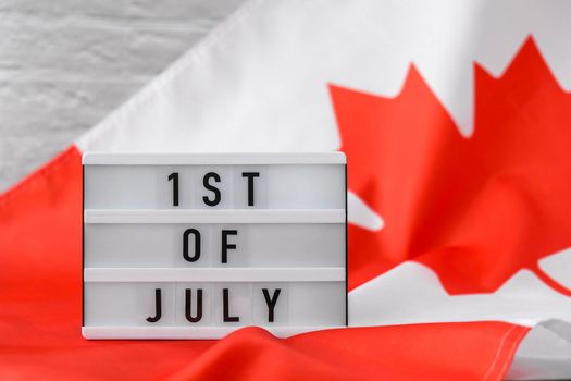The National Flag of Canada. Lightbox with text Canadian 1ST OF JULY Flag or the Maple Leaf. Patriotism. International relations concept. Independence day
