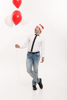 Christmas Concept - Handsome happy Business man walking with red balloon celebrate merry christmas and happy new year wear santa hat.