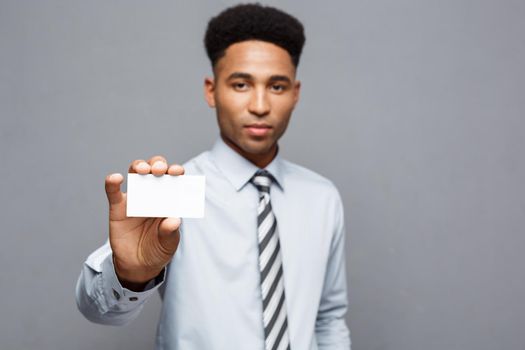 Business Concept - Happy handsome professional african american businessman showing name card to client.