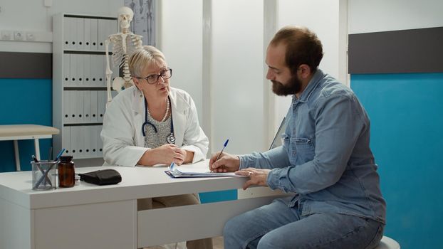 Sick patient signing checkup documents to receive medication