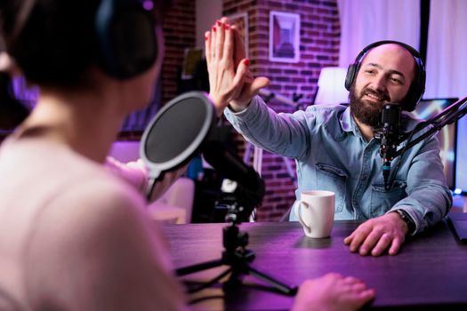 Male blogger having conversation with colleague on podcast show