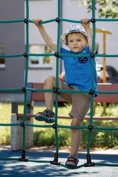 Little boy, playground and climbing rope tower