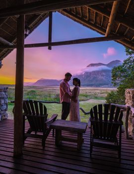 couple man and woman mid age in front of their lodge during vacation in South Africa, Mountains and grassland near Hermanus at the garden route Western Cape South Africa Whale coast