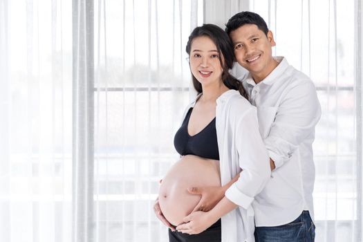 pregnant woman with husband with window background