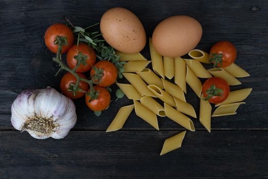 kitchen background with noodles, eggs, cherry tomatoes, and garlic