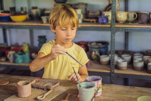 Boy doing ceramic pot in pottery workshop