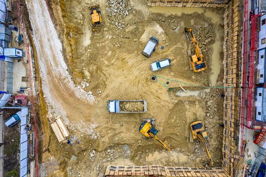 Heavy construction equipment working at the construction site. Aerial view from drone