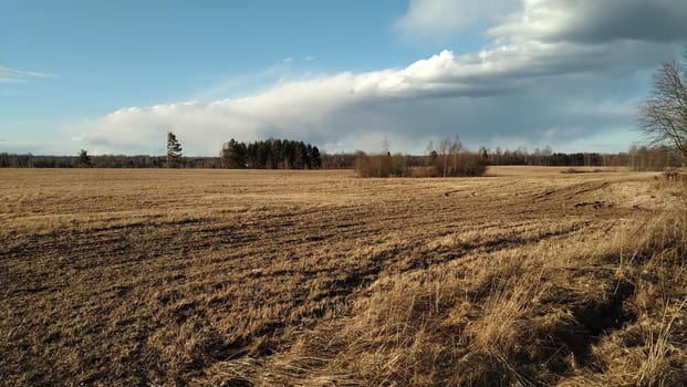 Cloudy front over a plowed field.