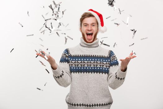 Chirstmas Concept - Happy young caucasian beard man throwing confetti celebrating for Christmas day.
