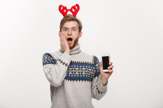 Holiday and lifestyle concept - young beard handsome man surprising with something in mobile phone.