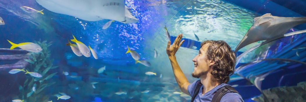 curious tourist watching with interest on shark in oceanarium tunnel BANNER, LONG FORMAT