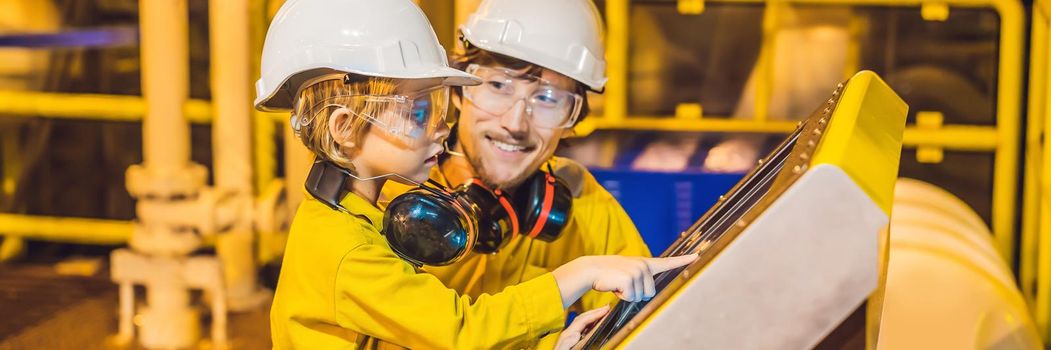 BANNER, LONG FORMAT A young man and a little boy are both in a yellow work uniform, glasses, and helmet in an industrial environment, oil Platform or liquefied gas plant looking at a screen.