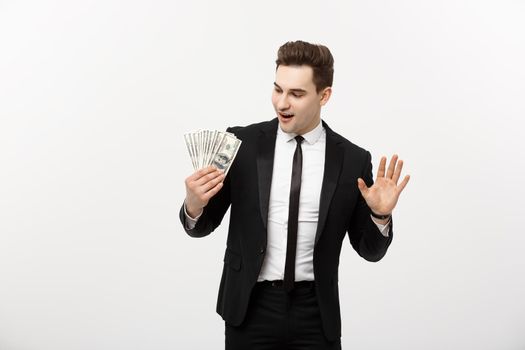 Cheerful businessman holding group of dollar bills on a gray background.