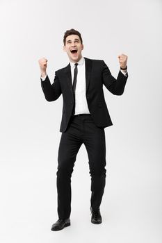 Business Concept: Full-length Portrait excited handsome business man with arms raised in success. Isolated on grey background.