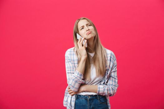 Bored girl calling on the phone and looking crazy on a pink background