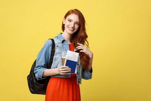 Travel and Lifestyle concept: Full length studio portrait of pretty young student woman holding passport with tickets. Isolated on bright yellow background.