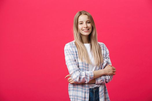 Smiling beautiful woman portrait with crossed arms on pink background