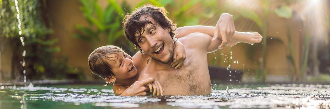 Dad and son have fun in the pool BANNER, LONG FORMAT