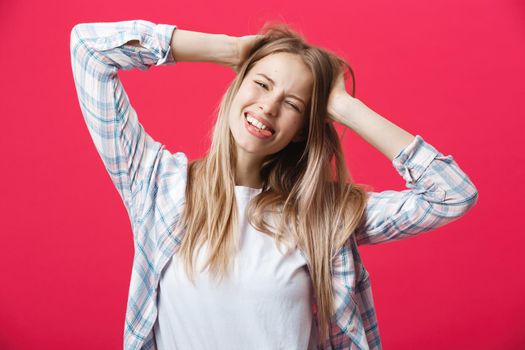 Gorgeours young Caucasian woman with healthy clean skin and beautiful set of features over pink background looking at camera with shy charming smile.